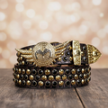Black rhinestone belt with gold angel wing buckle and round studded strap.